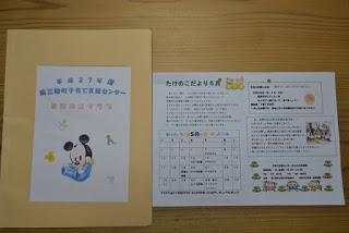 左側にミッキーマウスのイラストと文字が乗った白い紙が貼られた黄色いフォルダー、右側にはカレンダーや案内が書かれた「たけのこだより」の紙が並んでいる写真