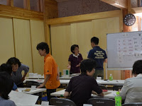 受講生が席の周りに集まって相談をしたり、講師と話をしている授業風景の写真