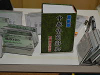 机の上に分厚い中国語の辞書とたくさんの席札が置かれている写真