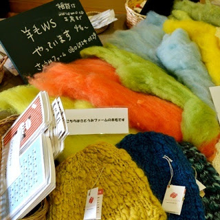 テーブルの上にカラフルな羊毛と手編みの帽子が並べられている写真