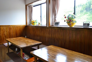 大きな窓から日差しが届く店内のテーブル2台を写した写真