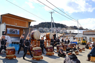 イベントのステージ前で和太鼓を力強く演奏する複数の男性が並び、躍動感あふれるパフォーマンスを披露している写真