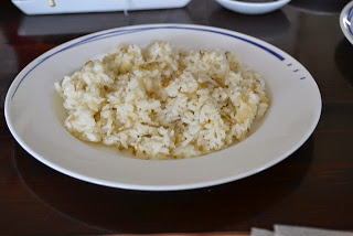 白いお皿に盛られた海産物入りの炊き込みご飯の写真