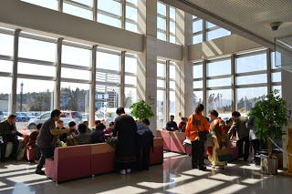 着物や様々な衣装を身にまとった参加者たちが、全面ガラス張りの会場のロビーに集まっている写真