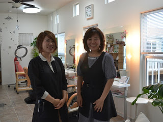 明るく清潔な店内で、笑顔の女性スタッフ二人が並んで立っている写真