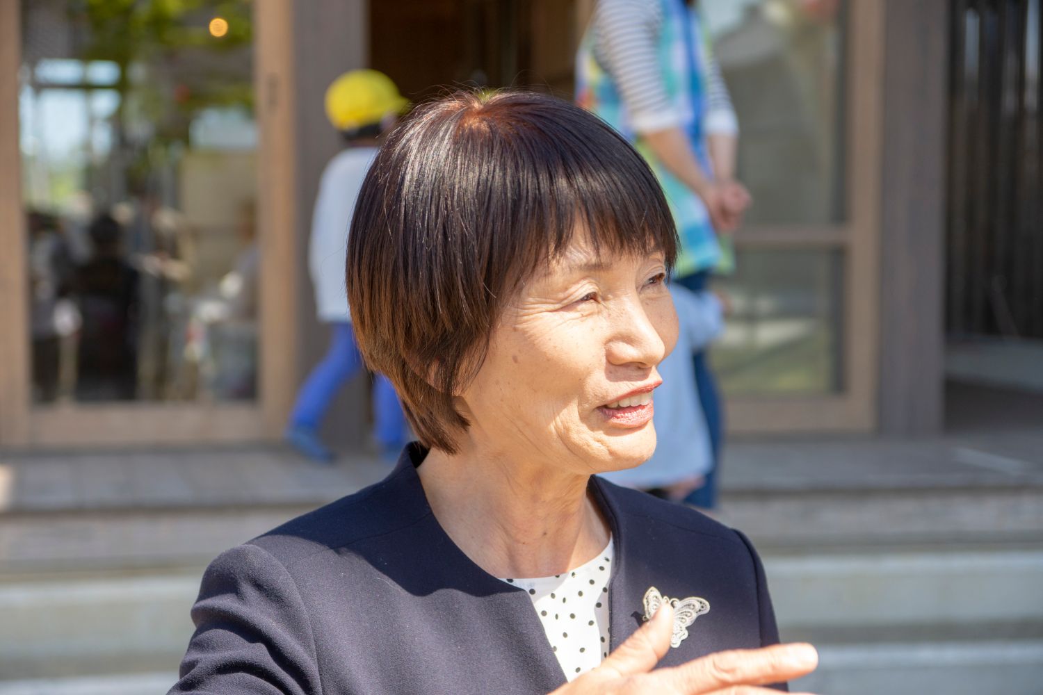 笑顔で話をしている紺色のスーツ姿の鳴海さんをアップで撮影した写真