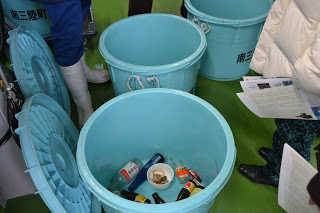 水色のポリバケツの中に瓶などが入っている写真