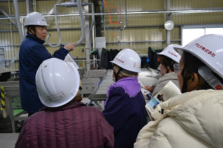 機械の前で櫛田さんの説明を聞いている入谷婦人会の皆さんの写真