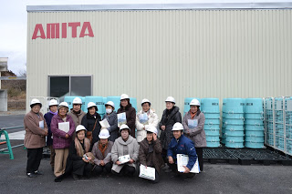 AMITAの施設前に並んだ入谷婦人会の皆さんと櫛田さんの集合写真