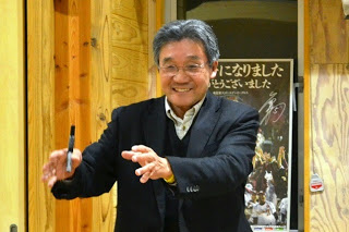 教室の中で右手にペンを持ち、両手を前に出してにこやかに話しながら講義を進めている小野寺講師をアップで撮影した写真