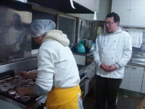 調理場で2人のパティシエが作業を行っている様子の写真