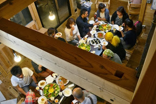 たくさんの料理が並んだテーブルを部長会の皆さんが囲んで座り、談笑しながら食事を楽しんでいる様子を真上から撮影した写真