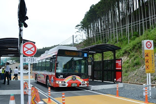 屋根付きのバス停に赤いデザインのJRバスが停車している写真