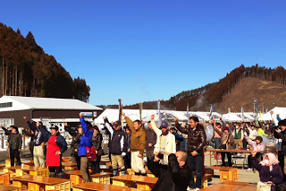 観客たちが掛け声に合わせて一斉に拳を掲げ、イベントの盛り上がりを感じさせる様子の写真