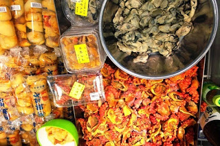 パック詰めされたうにやホヤ、牡蠣などの海産物がぎっしりと並び、上部に黄色い値札がつけられている売り場の写真