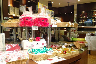 宮城の特産品やお菓子、オクトパス君ののキャラクターぬいぐるみなどが棚に陳列され、照明に照らされた売り場の写真