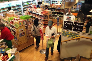 「宮城ふるさとプラザ」の店内に多くの商品棚が並び、買い物客がレジに並んだり商品を選んだりしている様子の写真