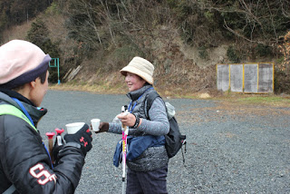 砂利の広場で紙コップを手にしている2人の女性参加者の写真