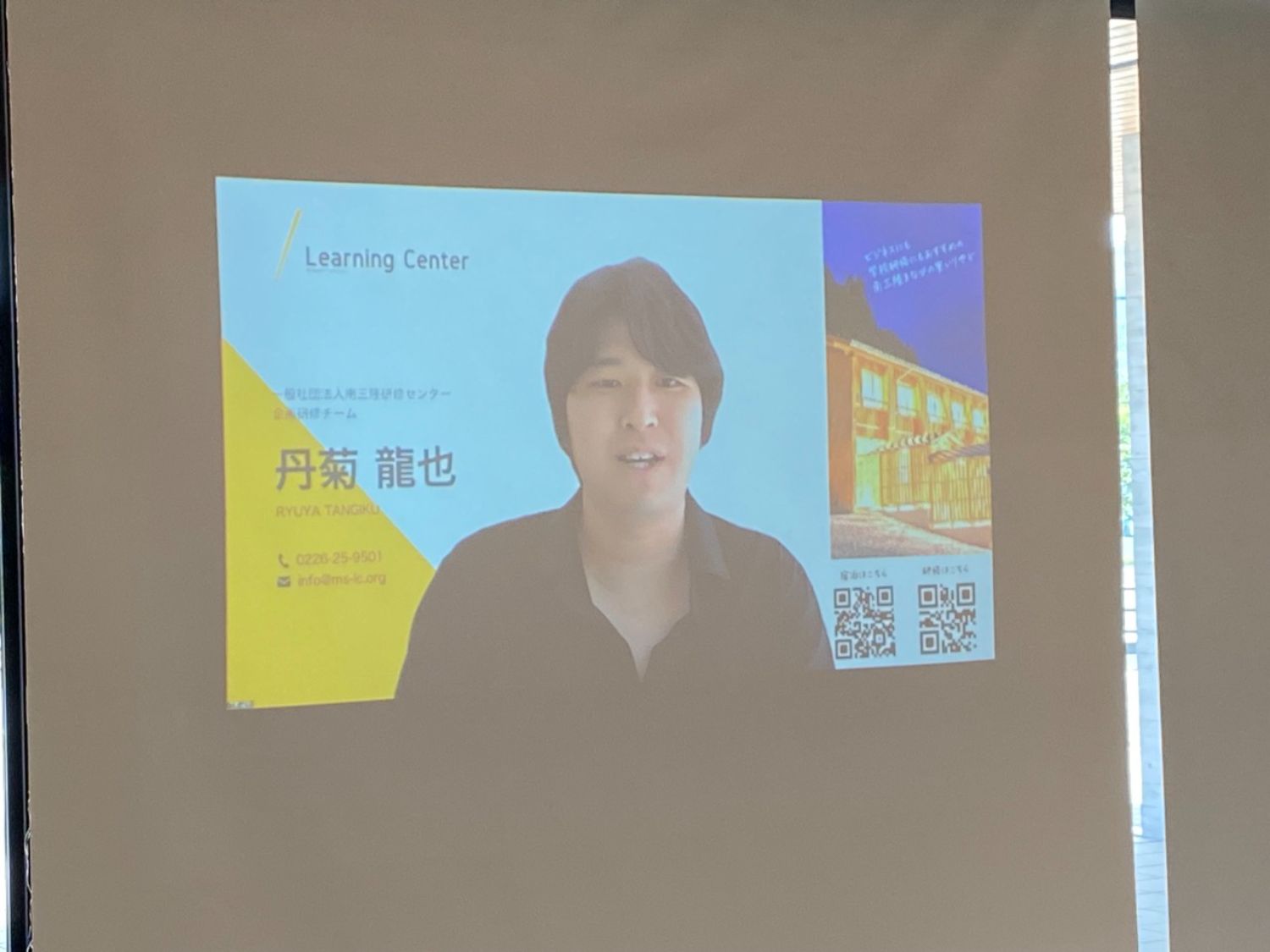 スライドに大きな丹菊さんの写真と連絡先情報が表示されている写真