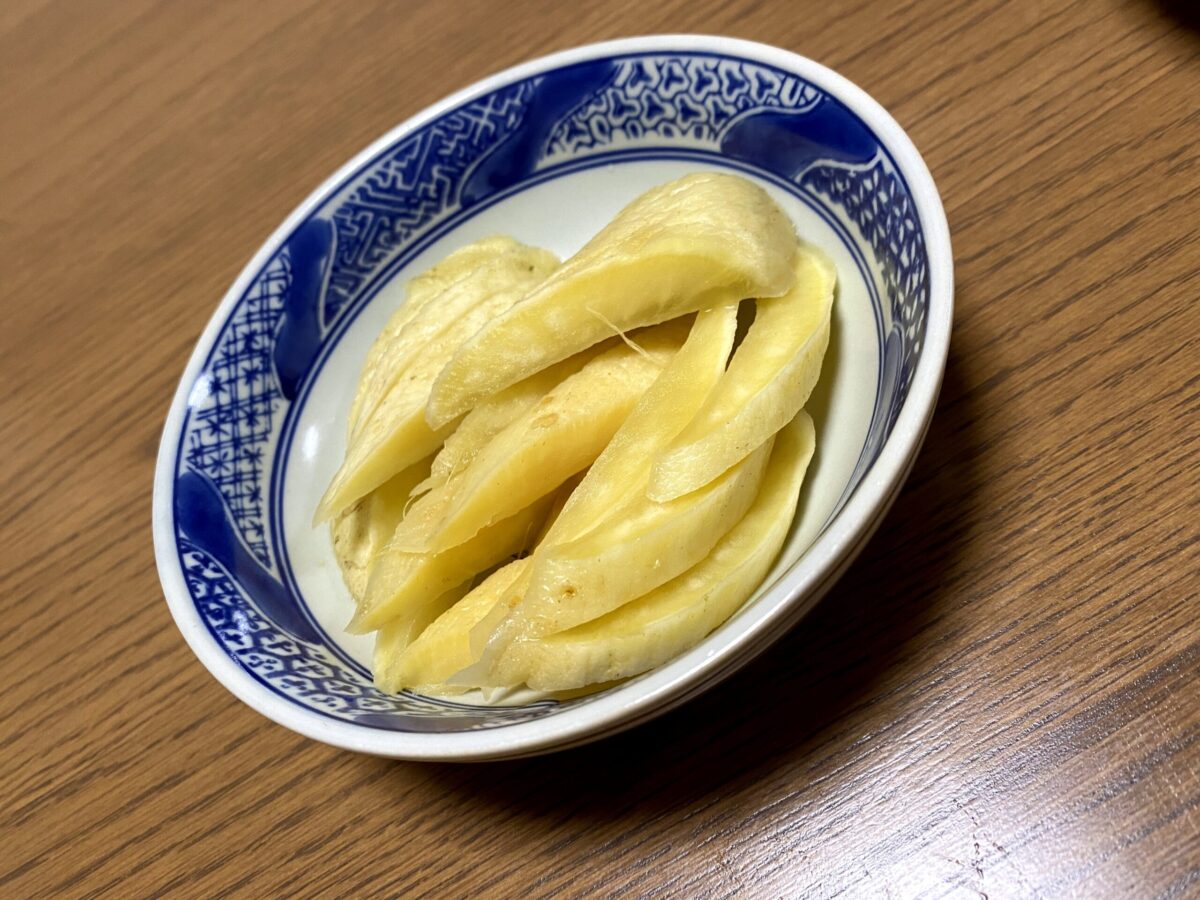 青と白の模様の器に盛られた、黄色く漬けられたたくあんが細く切られて並んでいる漬物の写真