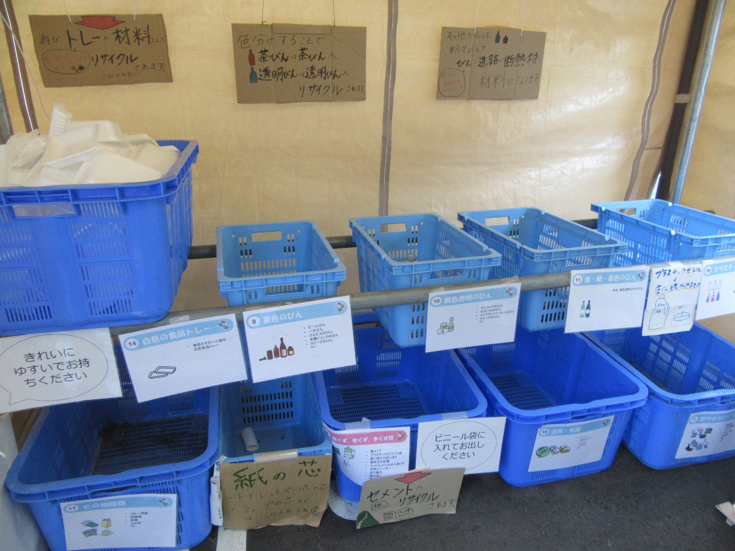 青いプラスチックのかごが並んでいるリサイクルステーションの写真