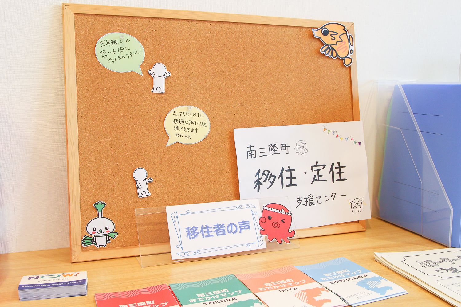 「南三陸町 移住・定住 支援センター」と書かれた紙や、住民の声を紹介する吹き出しメッセージが貼られた木製のコルクボードの写真