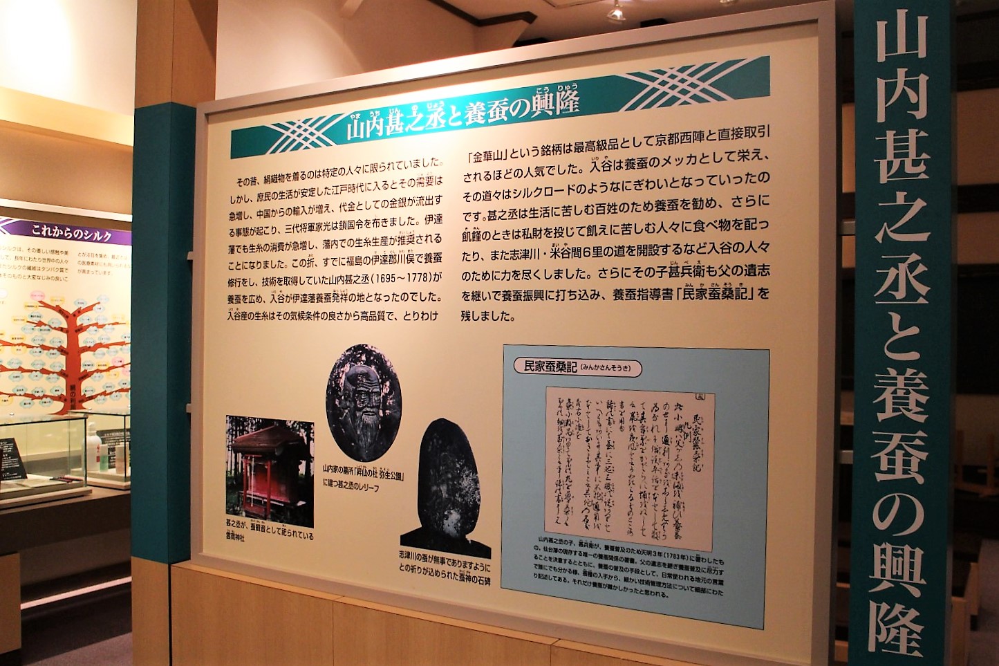 展示館にある案内パネルで、江戸時代中期に養蚕の発展に尽力した山内甚之丞という人物とその活動について、彼の遺訓や民家蚕業記(みんかさんぎょうき)などの資料とともに紹介されている展示の様子を写した写真