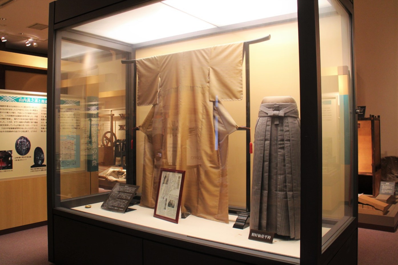 日本の伝統的な和服である着物と袴がガラスケースの中に展示されている写真