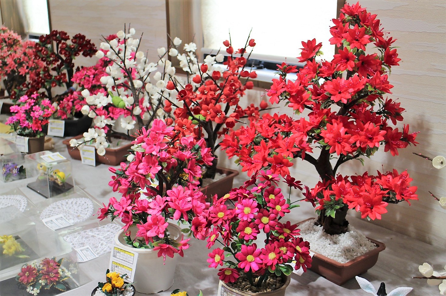 色とりどりの造花が鉢植えにされて並べられている写真