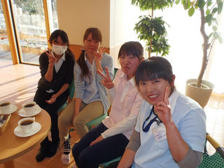 介護士の女性4名がピースサインで笑顔で映っている写真