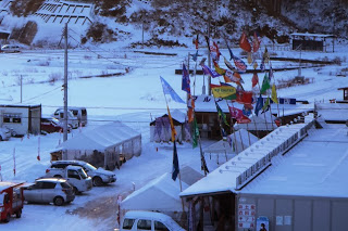 色とりどりの旗が立てられた仮設商店街にも周辺に雪が積もっている様子を写した写真