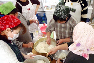 何人かの参加者が炊き上がったご飯を手分けしてボウルに移している様子の写真