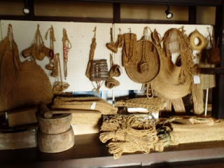 藁で作られたさまざまな昔の道具が壁や棚に展示されている展示コーナーを写した写真