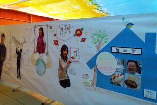 赤いツバキのイラストが描かれた壁の下に「南三陸椿ものがたり」と書かれたプレートを両手で支えている女性の写真や、煙突がついた水色の家の中にショートケーキやパンなどの写真とパティシエの男性の笑顔の写真が4つの窓に分割されて展示されている写真