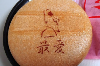 「最愛」という文字とモアイをモチーフにしてシルエットが焼き印された丸い最中を大きく写した写真