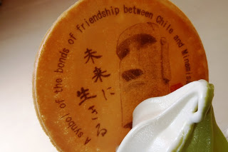 「未来に生きる」と日本語で書かれた文字と、英語で友情の象徴と書かれた焼き印が入ったイラスト入りの円盤ウエハースをソフトクリームとともに写した写真