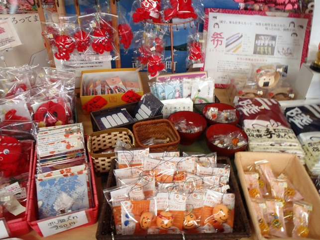 机の上に手作りマスコットや和風の小物、布製品などがたくさん並べられている売り場の写真