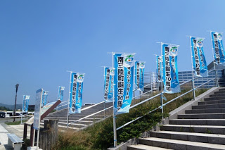 石段の横に「南三陸町震生10年」と書かれた青い旗が複数並んだ写真