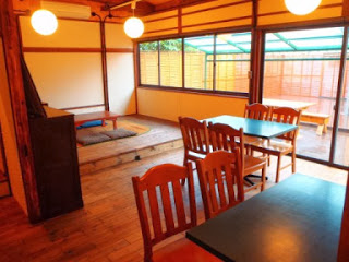 座敷と椅子席があり、天井の丸い照明が複数ある明るい店内の全景写真