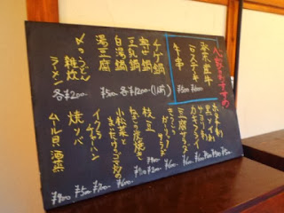 黒板に黄色と白のチョークで手書きされたメニューの写真