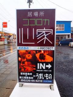 居場所「ココロカ山家」と書かれた看板で、下部に料理の写真と営業時間や連絡先などが記載された案内板の写真