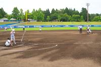 ピッチャーがマウンド上から投球動作に入り、バッターが打席で構え、守備陣が緊張感を持って守備位置に就いている様子の写真