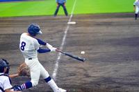 背番号8番の打者が、投げられたボールをバットで打ち返そうとしている瞬間の写真