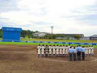 選手たちと審判団が、スコアボードの方を向いて整列している写真