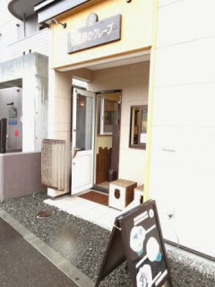 店舗外観で、ガラスドアが開いていて、入口前に黒板メニューが置かれている様子の写真