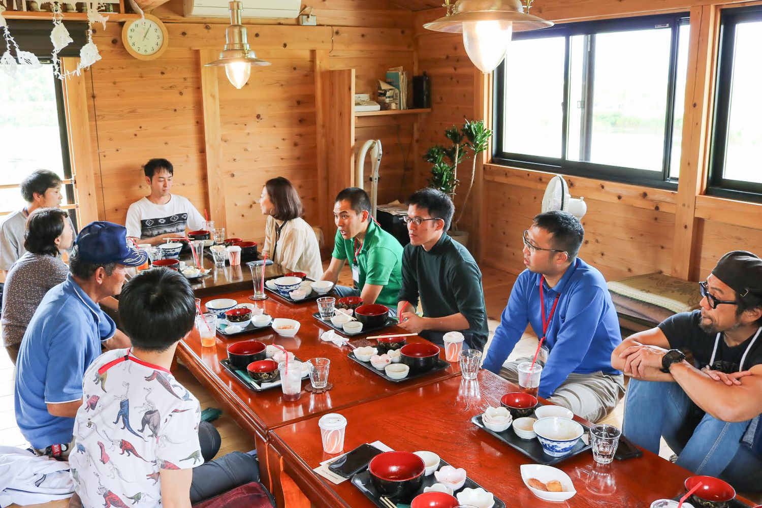 木造の温かみある室内で、食事が終わったあと男女が座卓を囲んで会話をする様子の写真