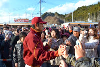牧田明久外野手が優勝報告会の会場で集まったファンと笑顔でハイタッチをしながら歩いている写真