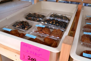 トレーの中にパック詰めされたひじき煮や揚げ物などの惣菜が並べられている惣菜販売コーナーの写真