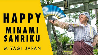 HAPPY MINAMI SANRIKU MIYAGI JAPAN(石鳥居の前で首にタオルをかけた高齢の女性が扇子を広げて踊っている写真)