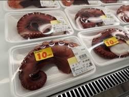 それぞれ1本ずつタコの足が入っている透明なパックが冷蔵売り場に並べられた写真